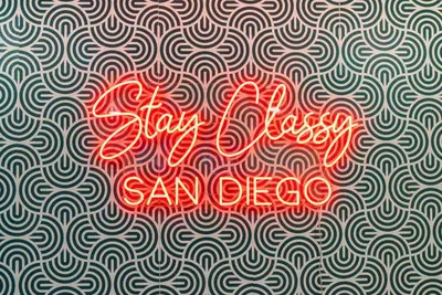 a red neon sign on a wave pattern with the words stay disco san oreo at SDSU and Downtown Less Than 10 Min, Game Room, and Fire Pit in La Mesa