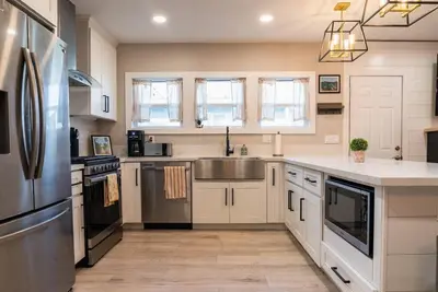 a kitchen with white cabinets and a stainless steel refrigerator at SDSU and Downtown Less Than 10 Min, Game Room, and Fire Pit in La Mesa