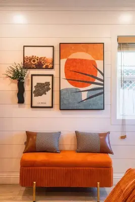 an orange bench in a room with pictures on the wall at SDSU and Downtown Less Than 10 Min, Game Room, and Fire Pit in La Mesa
