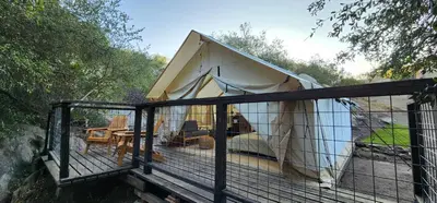 a tent on a deck with a fence at Gentle and Cozy Comfort in an Off-Grid Retreat in Fallbrook