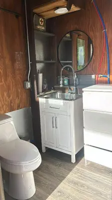 a bathroom with a toilet and a sink and a mirror at Gentle and Cozy Comfort in an Off-Grid Retreat in Fallbrook
