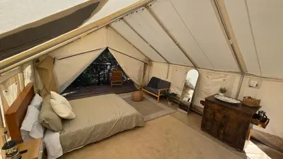 a bedroom in a tent with a bed and a desk at Gentle and Cozy Comfort in an Off-Grid Retreat in Fallbrook