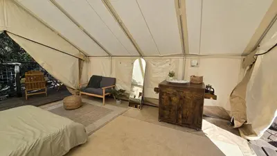 a bedroom with a tent with a bed and a table at Gentle and Cozy Comfort in an Off-Grid Retreat in Fallbrook