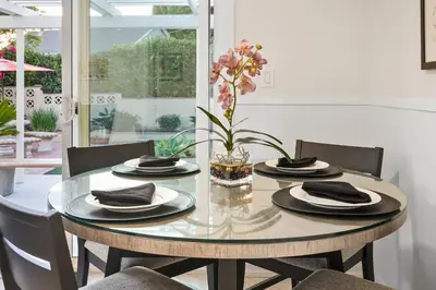 a dining room table with plates and a vase of flowers at Hills Hideaway by CoastVH - Luxury Midtown 3br in San Diego