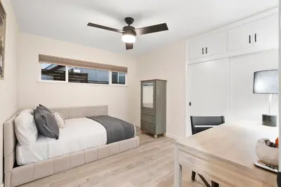 a bedroom with a bed and a desk and a ceiling fan at Hills Hideaway by CoastVH - Luxury Midtown 3br in San Diego