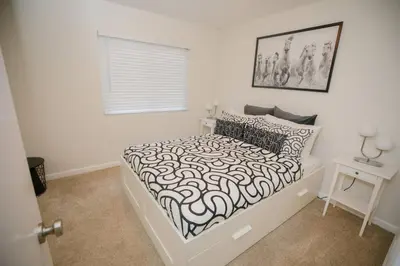 a bedroom with a bed with a black and white comforter at 2 private masters, new beds & furniture, sleeps 12 in San Diego