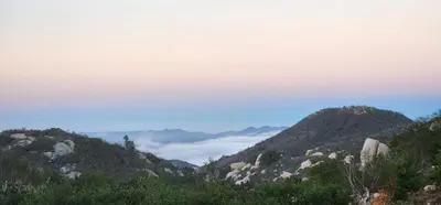a view of a mountain with clouds in the distance at A Cozy Sunrise Glamping Escape with Panoramic View in Fallbrook