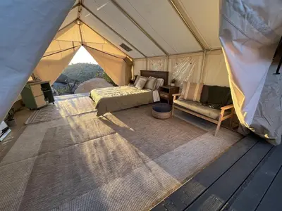 a tent with a bed and a couch in it at A Cozy Sunrise Glamping Escape with Panoramic View in Fallbrook