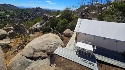 a bench sitting on the side of a mountain at A Cozy Sunrise Glamping Escape with Panoramic View in Fallbrook