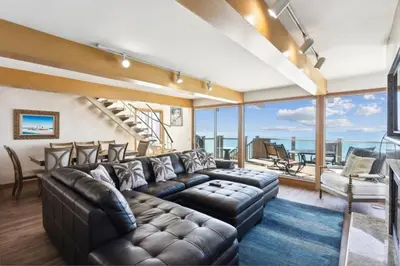 a living room with a leather couch and a large window at Ocean View beach house Ocean View beach house-STR14-0105 & STR14-0133 in Dana Point