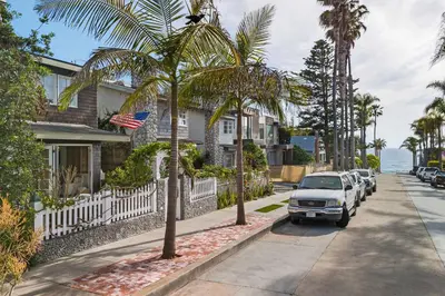 a street with cars parked in front of a house at Nantucket-Style - Steps to Beach Rooftop Deck Ocean Views in San Diego