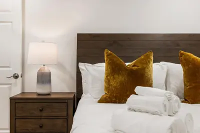 a bedroom with a bed with white sheets and gold pillows at # Marbella Lane - Home with Ocean & Golf Course Views in San Clemente