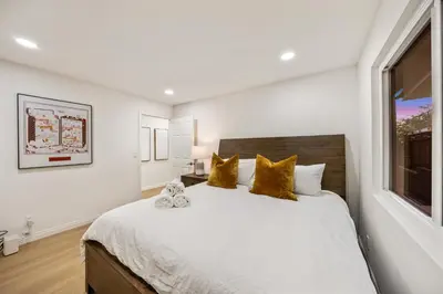 a bedroom with a large white bed with yellow pillows at # Marbella Lane - Home with Ocean & Golf Course Views in San Clemente