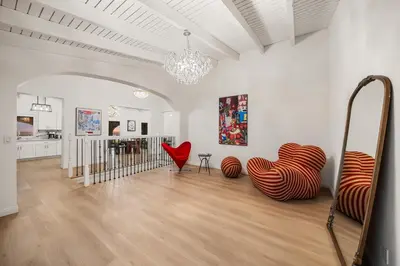 a living room with red chairs and a chandelier at # Marbella Lane - Home with Ocean & Golf Course Views in San Clemente