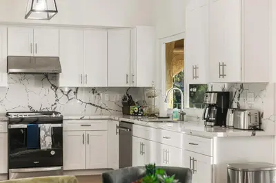 a white kitchen with white cabinets and appliances at # Marbella Lane - Home with Ocean & Golf Course Views in San Clemente