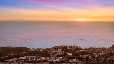 a view of a city and the ocean at sunset at # Marbella Lane - Home with Ocean & Golf Course Views in San Clemente