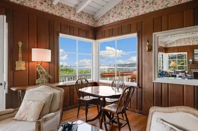 a dining room with a table and chairs and windows at The Porter House - Sweeping Ocean Views - La Jolla in San Diego