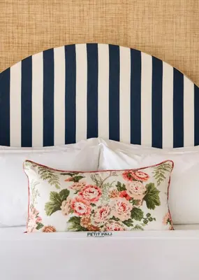 a pillow sitting on a bed with a striped headboard at Le Petit Pali Laguna Beach in Laguna Beach