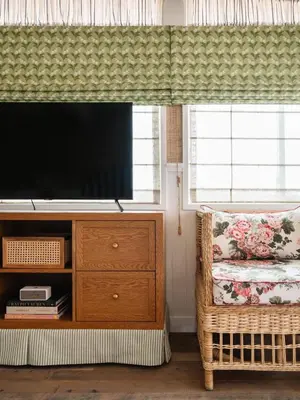 a living room with a television and a wicker chair at Le Petit Pali Laguna Beach in Laguna Beach
