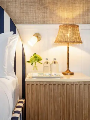 a bed with a lamp and two bottles on a night stand at Le Petit Pali Laguna Beach in Laguna Beach