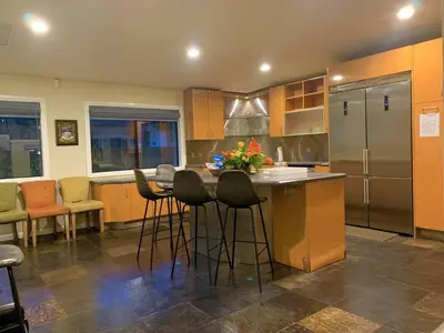 a kitchen with a bar with stools and a refrigerator at PACIFIC BEACH ESTATE water view in San Diego