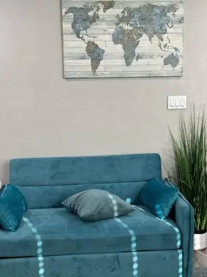 a blue couch with a map of the world on the wall at Home away from Home in San Diego
