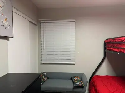 a bedroom with a bed and a couch and a window at Home away from Home in San Diego