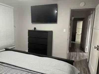 a bedroom with a dresser and a flat screen tv at Home away from Home in San Diego