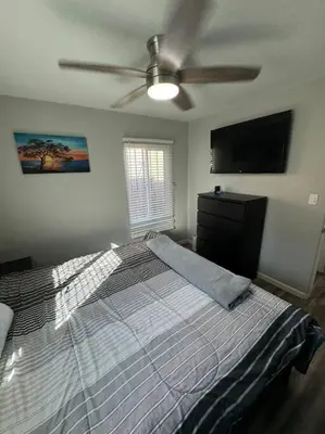 a bedroom with a bed and a ceiling fan at Home away from Home in San Diego