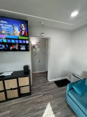 a living room with a blue couch and a flat screen tv at Home away from Home in San Diego