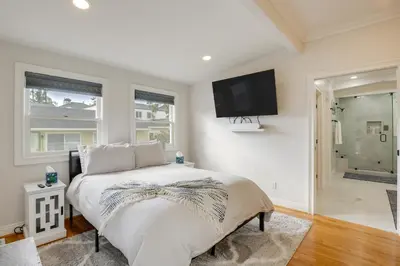 a bedroom with a bed and a tv on the wall at Steps to Balboa Park Sunny Historic Apartment in San Diego