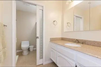 a bathroom with a sink and a toilet and a mirror at Majestic 5BR Villa with Guesthouse, Pool & Spa in Poway