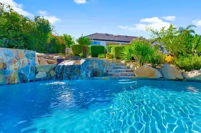 a swimming pool with a waterfall in a backyard at Massive 7BR Stunning MTN View Zen Retreat Pool and Spa in Ramona
