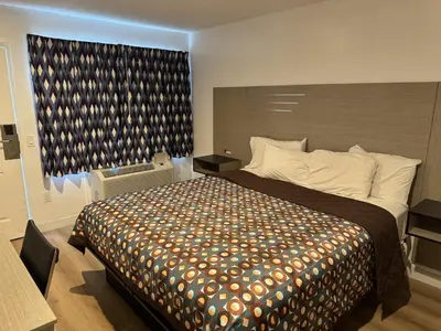 a bedroom with a large bed and a large window at Sun Leisure Motel in Menifee