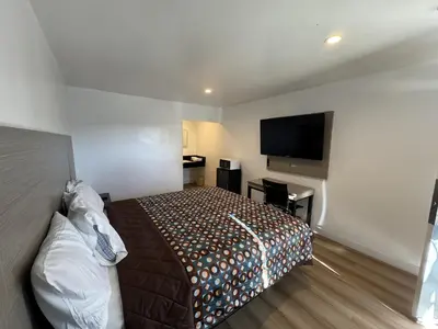a bedroom with a bed and a flat screen tv at Sun Leisure Motel in Menifee