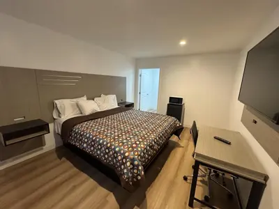 a bedroom with a bed and a flat screen tv at Sun Leisure Motel in Menifee