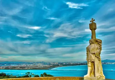 a statue with a cross on top of it next to the water at 1 Block to Sand Stylish Boho Retreat in San Diego