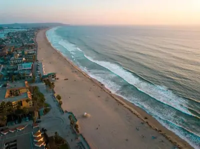 an aerial view of a beach at sunset at 1 Block to Sand Stylish Boho Retreat in San Diego
