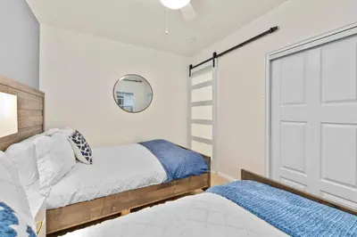 a bedroom with two beds and a mirror at PB 3BR Beach Retreat Hot Tub Mini Golf in San Diego