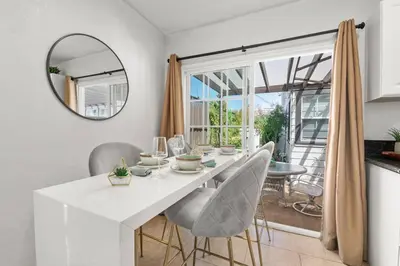 a dining room with a white table and chairs at PB 1BR BOHO with Parking, AC, and Large Patio in San Diego