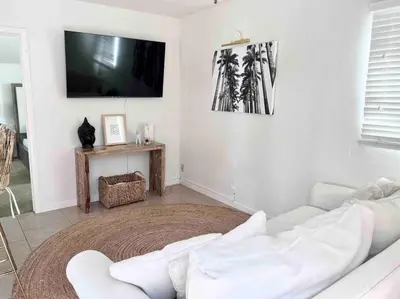 a living room with a white couch and a flat screen tv at PB 1BR BOHO with Parking, AC, and Large Patio in San Diego