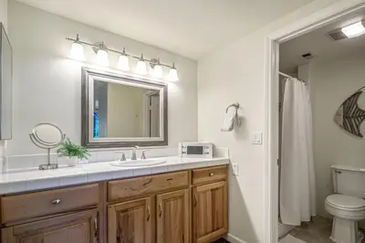 a bathroom with a sink and a mirror and a toilet at Encinitas Paradise | Seabluffe Gated Community w/ Beach Access in Encinitas