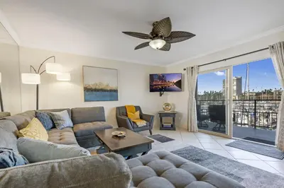 a living room with a couch and a ceiling fan at Serene Harborfront Condo | Unbeatable Views & Coastal Charm in Oceanside