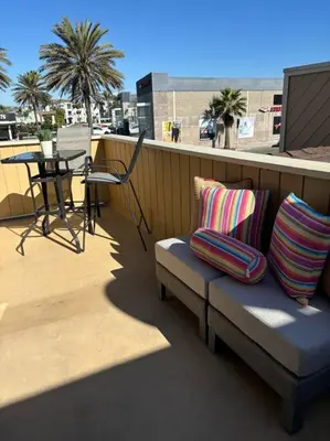 a bench with pillows on a balcony with a table at Newport Beach Rendezvous in Newport Beach