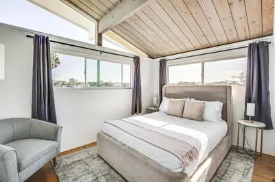 a bedroom with a bed and a chair and a window at 3 Mi to Balboa Park Water-View Condo with Balcony in San Diego