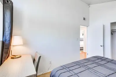 a bedroom with a bed and a desk with a lamp at 3 Mi to Balboa Park Water-View Condo with Balcony in San Diego