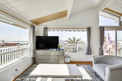 a living room with a television and large windows at 3 Mi to Balboa Park Water-View Condo with Balcony in San Diego