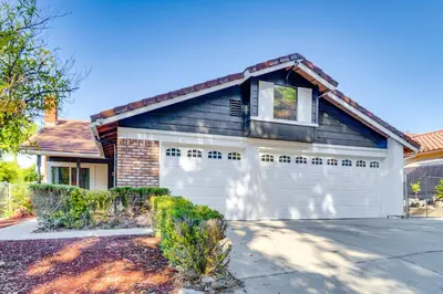 a blue and white house with a garage at Water-View Home with Hot Tub in Lake Elsinore! in Lake Elsinore