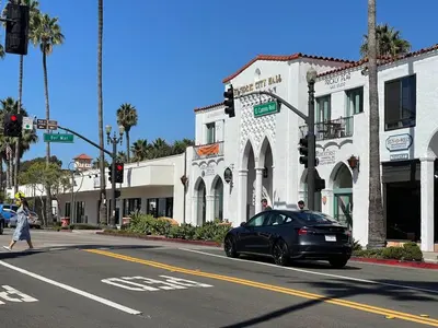 a black car driving down a street in front of a building at Walk To Beach 2BR Top Location - AA in San Clemente