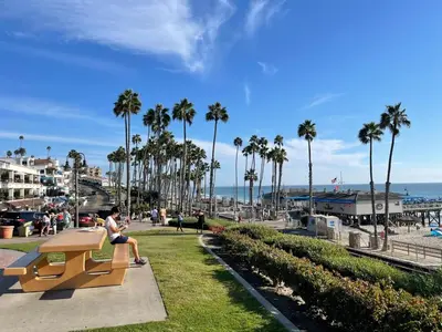 a woman sitting on a bench near the beach at Walk To Beach 2BR Top Location - AA in San Clemente